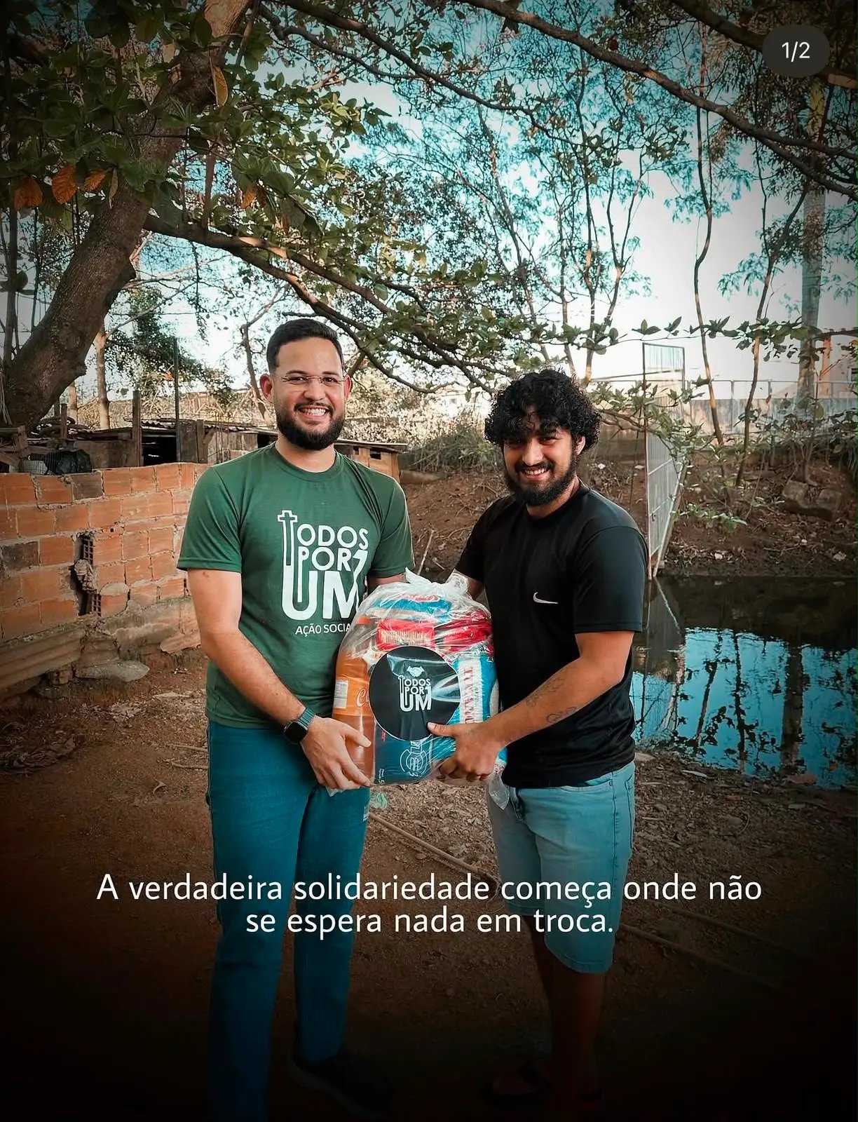 Voluntários da Todos Por Um entregando uma cesta básica